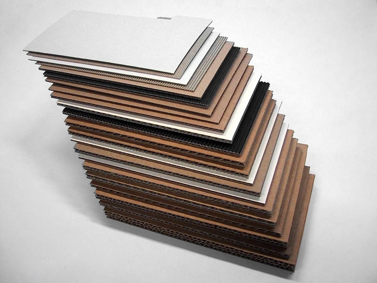 A stack of corrugated and folding-carton board samples, each with a different flute