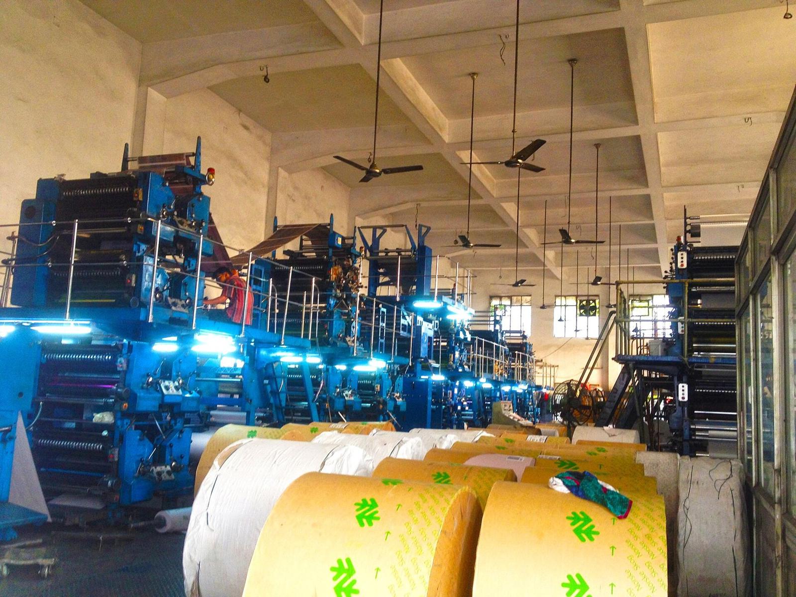 Offset presses and paper reels on a print-shop floor